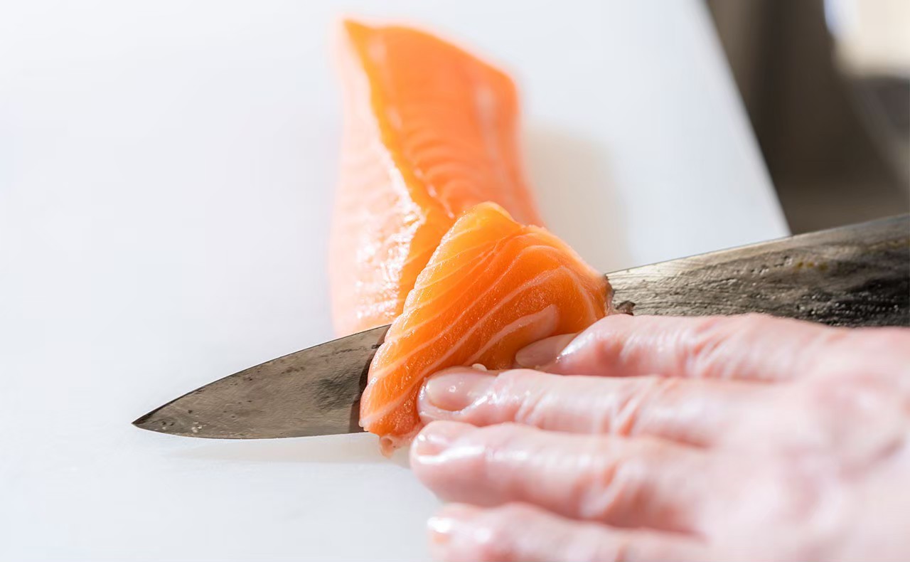 料理人のサーモン切りつけ